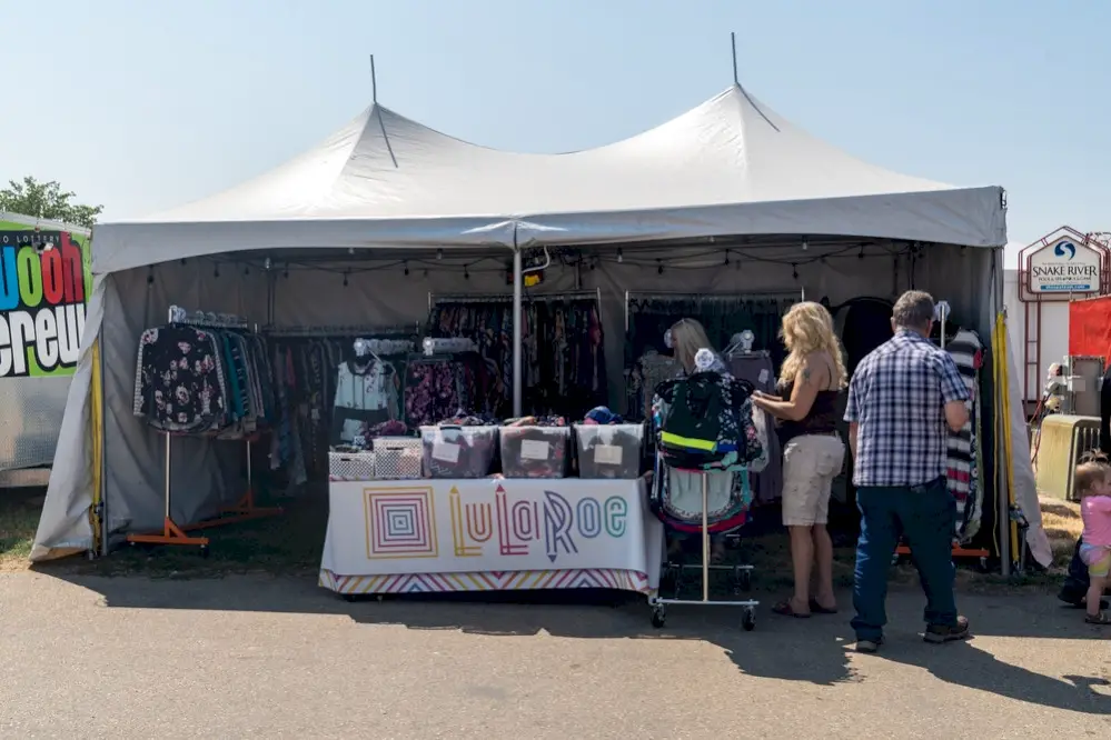 A direct seller at a fair in a booth selling Lularoe