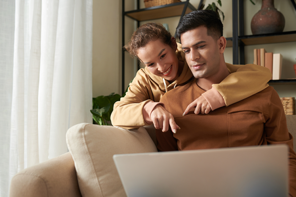 Couple looking at laptop screen on the couch